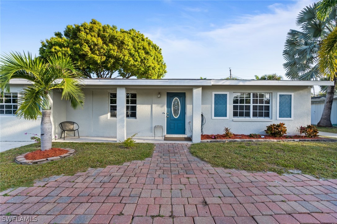 1447 Collins Road Fort Myers, FL 33919 - Photo 2 of 34 a front view of a house with a yard and potted plants