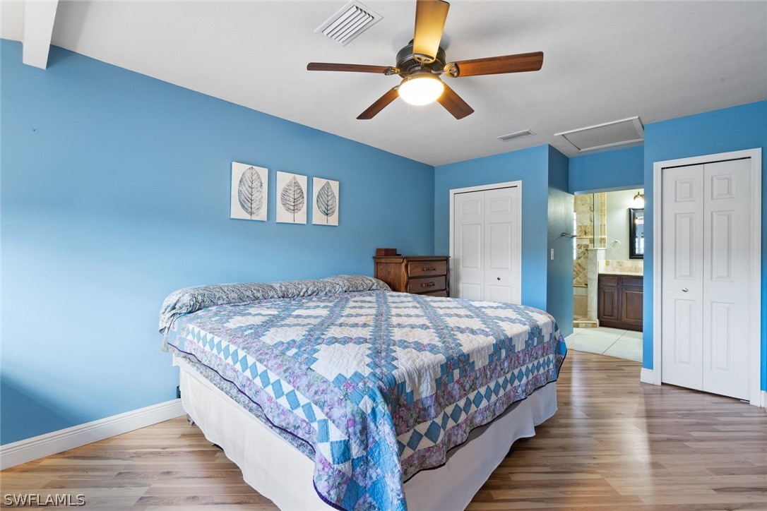 1447 Collins Road Fort Myers, FL 33919 - Photo 24 of 34 a bedroom with a large bed and a chandelier