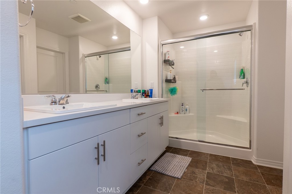 2464 Gunner Ridge Way Rialto, CA 92377 - Photo 15 of 42 a bathroom with a double vanity sink mirror and shower