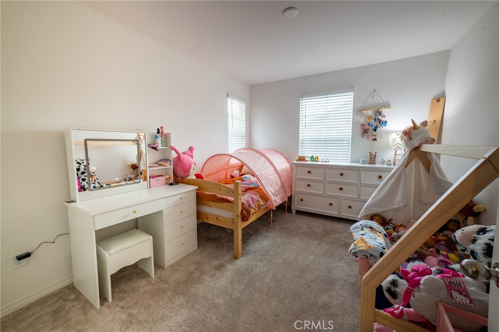 2464 Gunner Ridge Way Rialto, CA 92377 - Photo 16 of 42 a bedroom with a bed and a chandelier