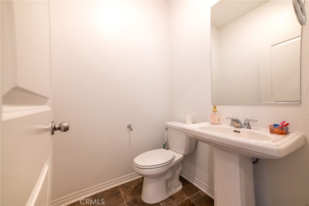 2464 Gunner Ridge Way Rialto, CA 92377 - Photo 20 of 42 a bathroom with a sink a toilet and a mirror