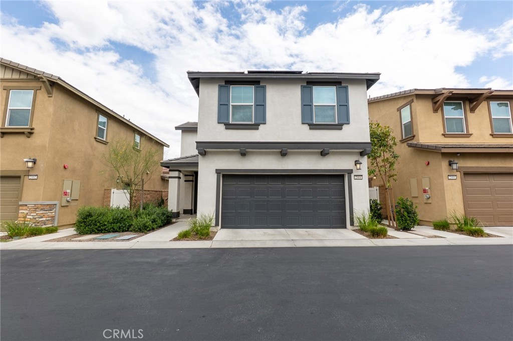 2464 Gunner Ridge Way Rialto, CA 92377 - Photo 2 of 42 a front view of a house with a yard and garage