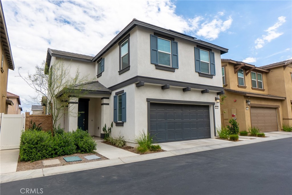 2464 Gunner Ridge Way Rialto, CA 92377 - Photo 3 of 42 a front view of a house with a yard and garage