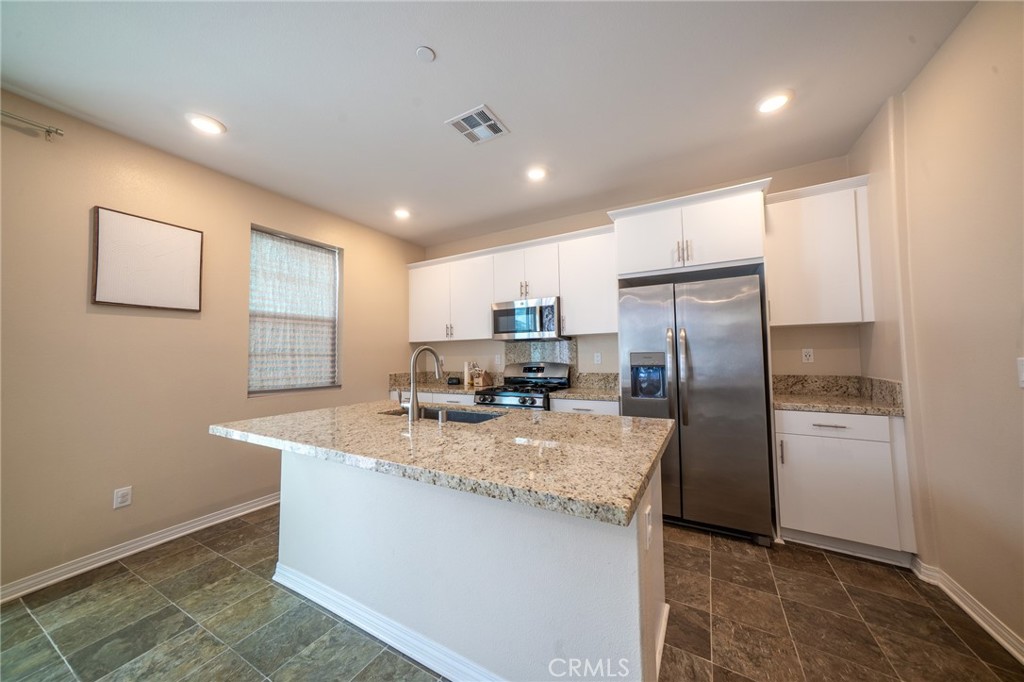 2464 Gunner Ridge Way Rialto, CA 92377 - Photo 7 of 42 a kitchen with refrigerator and countertop
