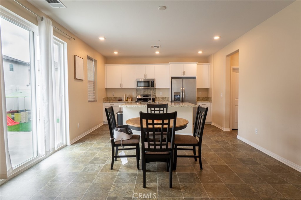 2464 Gunner Ridge Way Rialto, CA 92377 - Photo 9 of 42 a dining area with a table chairs and a kitchen