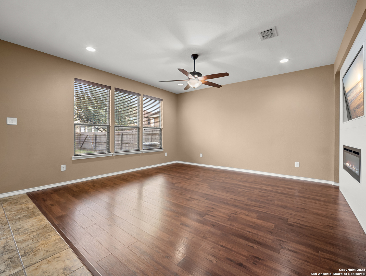 7514 Copper Cove Converse, TX 78109 - Photo 9 of 33 a view of an empty room with a window and wooden floor