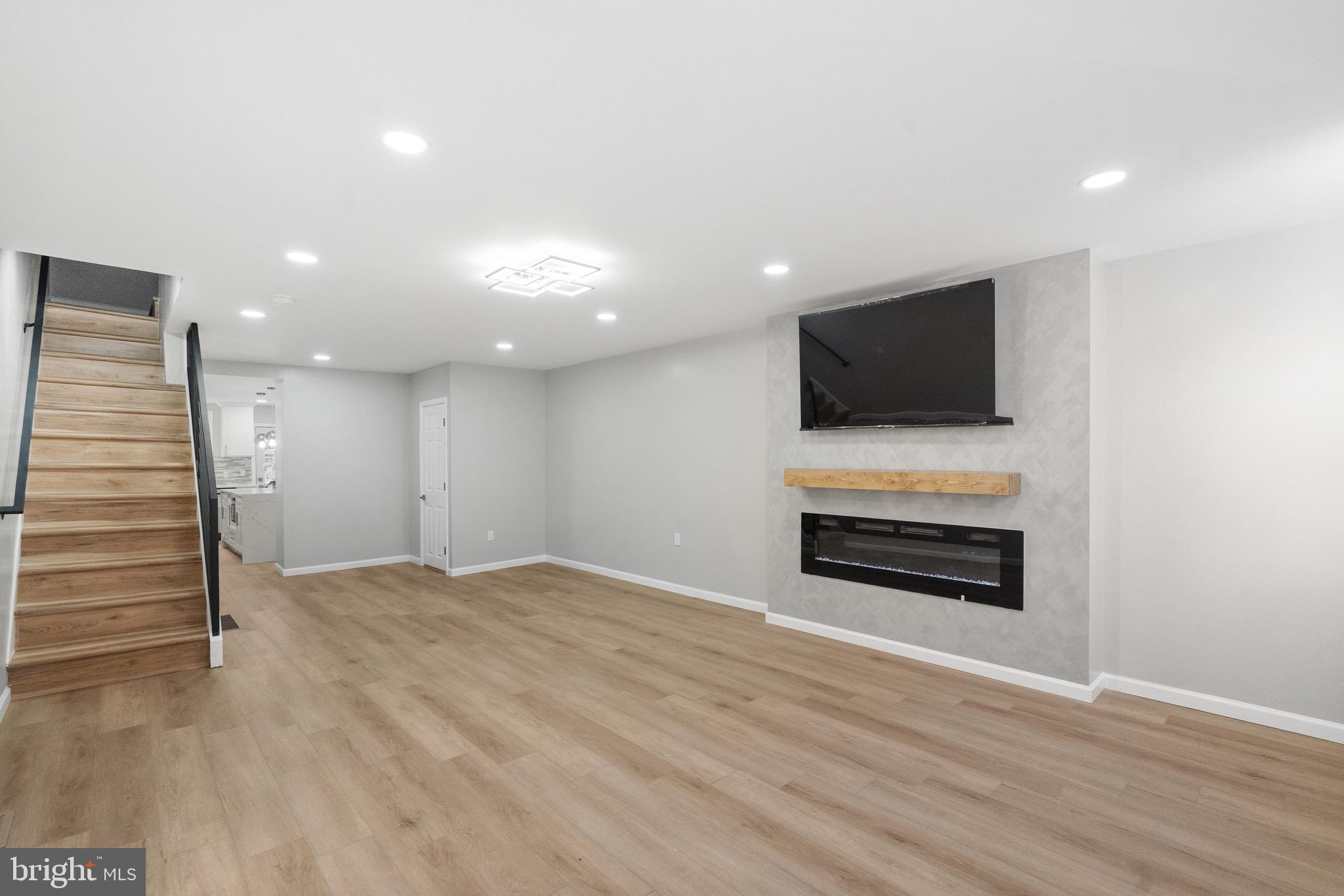 1203 Moore Street Philadelphia, PA 19148 - Photo 11 of 41 a view of a livingroom with a flat screen tv wooden floor and staircase