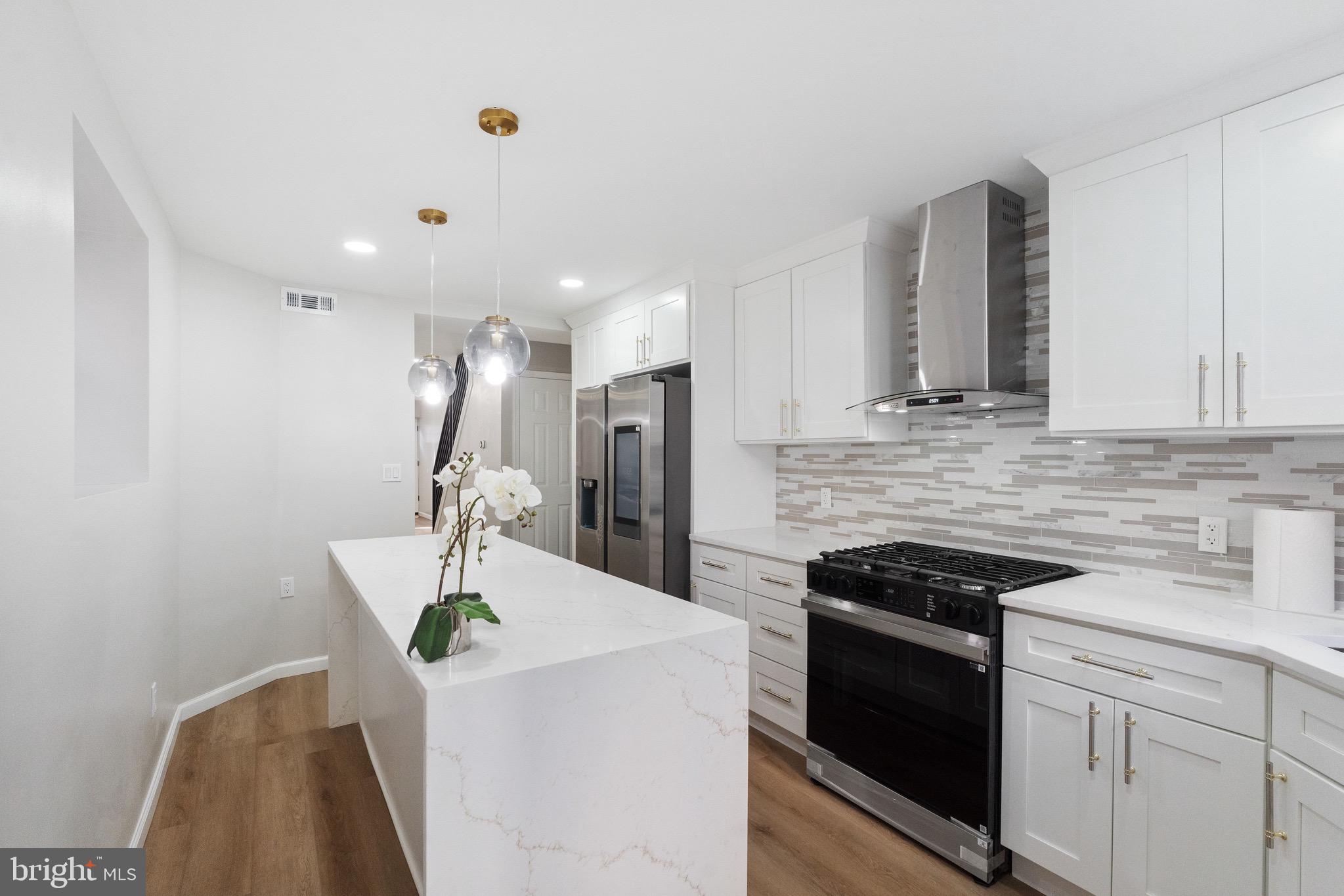 1203 Moore Street Philadelphia, PA 19148 - Photo 2 of 41 a kitchen with stainless steel appliances a white wooden cabinets