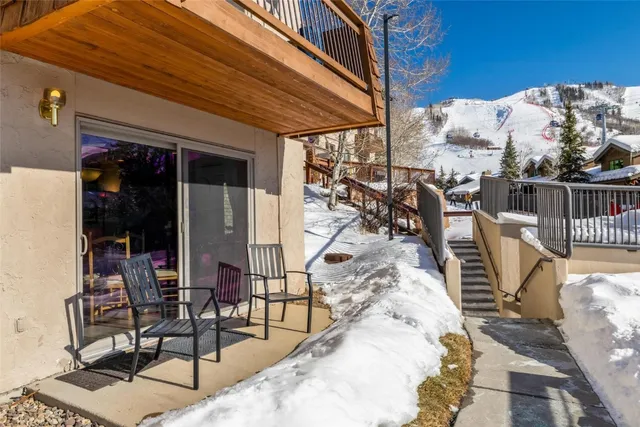 a view of a patio with table and chairs with wooden floor and fence