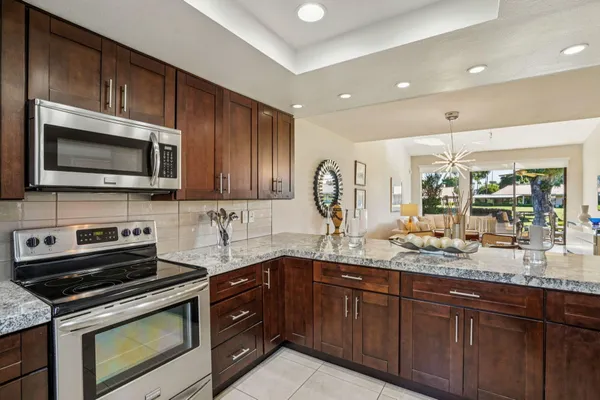 a kitchen with stainless steel appliances granite countertop a sink a stove microwave and cabinets