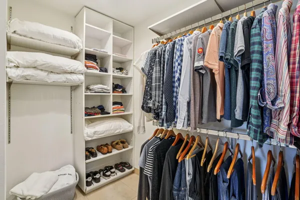 a view of walk in closet with clothes and shoes