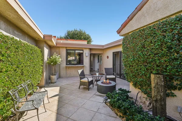 a view of a patio with chairs and potted plants