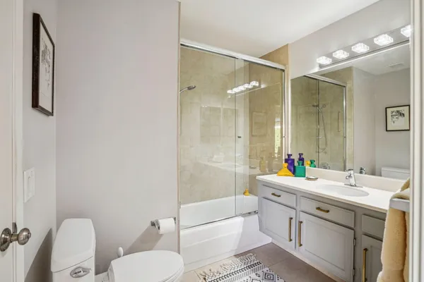 a bathroom with a double vanity sink toilet mirror and shower