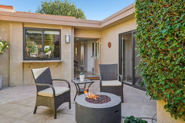a view of a patio with table and chairs and potted plants