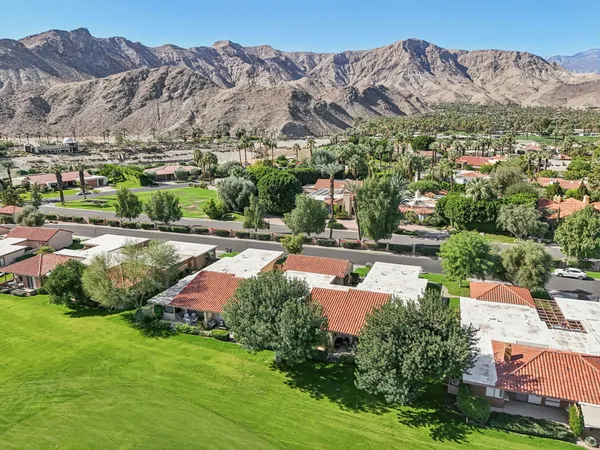 an aerial view of a house with yard and mountain view in back