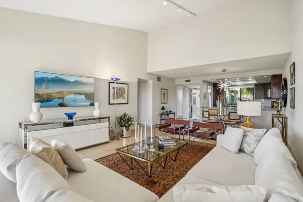 a living room with furniture and view of kitchen