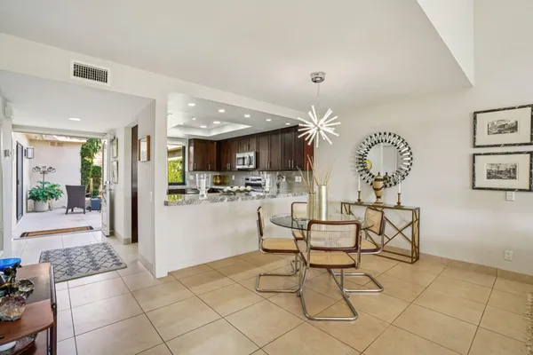 a living room with couches and kitchen view with wooden floor