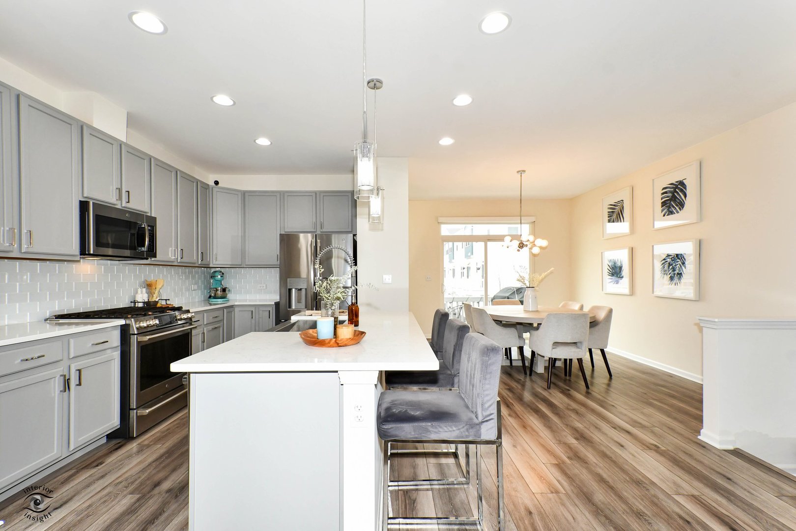 4154 Irving Road Aurora, IL 60504 - Photo 6 of 25 a open kitchen with stainless steel appliances granite countertop a stove top oven a refrigerator a dining table and chairs with wooden floor