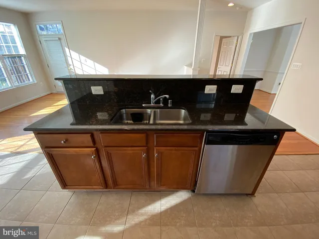 a kitchen with stainless steel appliances granite countertop a sink and a black granite counter tops
