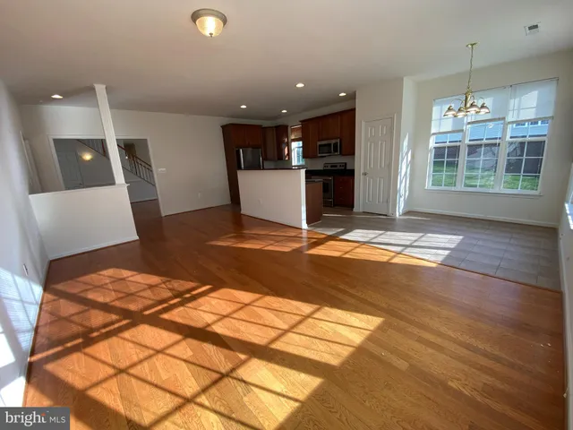 a view of a room with a sink and dishwasher with wooden floor