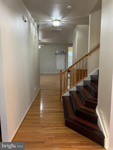 a view of entryway and hall with wooden floor