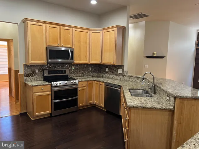 a kitchen with granite countertop a stove top oven sink and cabinets