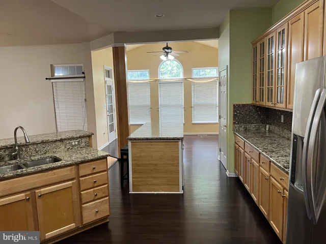 a bathroom with a granite countertop sink a mirror and a bathtub