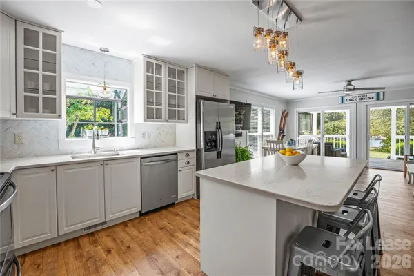 a kitchen with kitchen island granite countertop a sink cabinets and window