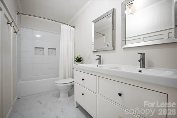 a bathroom with a double vanity sink mirror and toilet