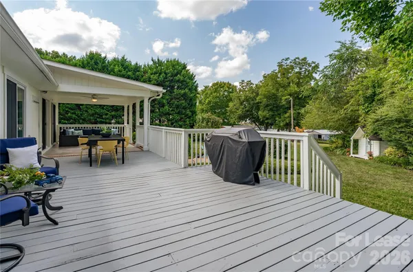 a view of a deck with table and chairs potted plants with wooden floor and fence