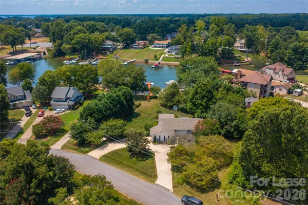 an aerial view of a house with yard and lake view