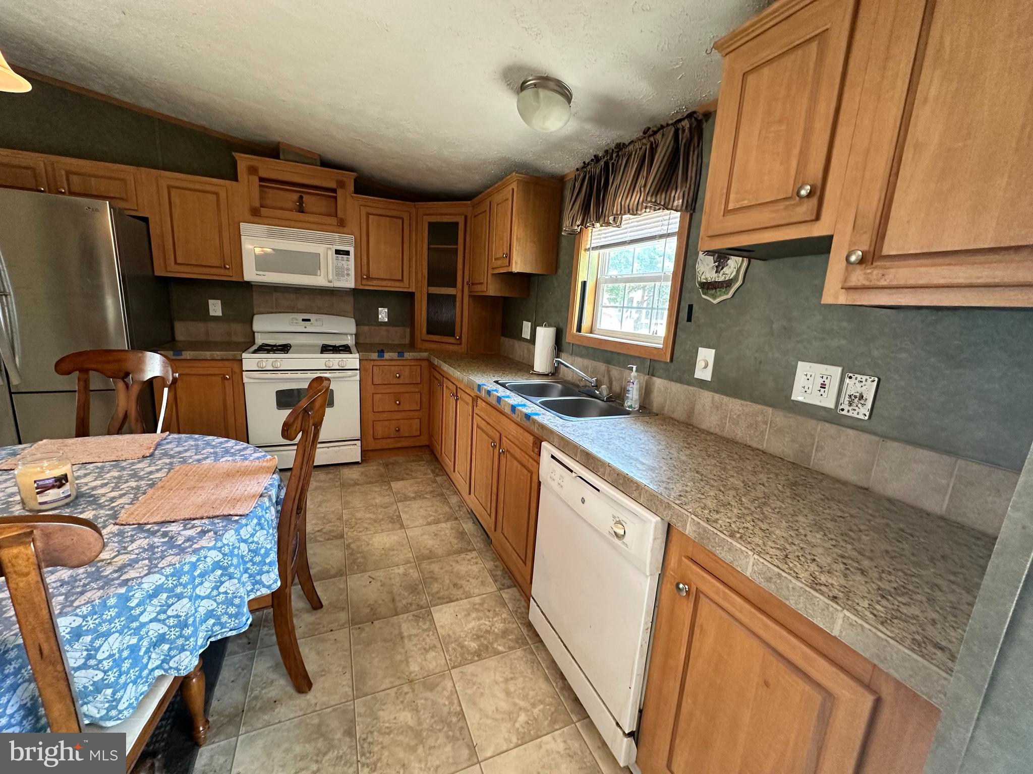 35390 Heron Road Millsboro, DE 19966 - Photo 5 of 25 a kitchen with granite countertop a sink a counter top space cabinets and stainless steel appliances