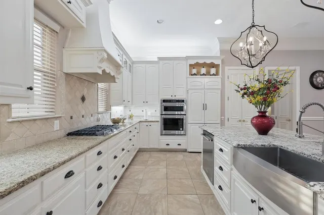 a large kitchen with stainless steel appliances kitchen island granite countertop a sink and cabinets