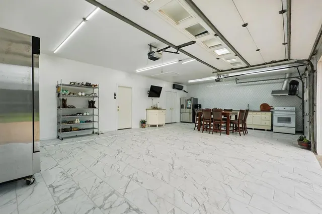 a view of a dining room and livingroom with furniture wooden floor a flat screen tv and a chandelier