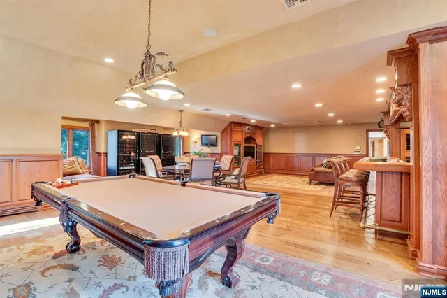 a dining hall with stainless steel appliances granite countertop a dining table and chairs with wooden floor