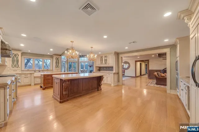 a kitchen with kitchen island granite countertop a sink stove and cabinets