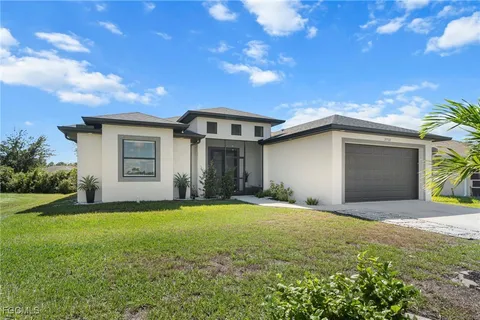 a front view of a house with a yard and garage
