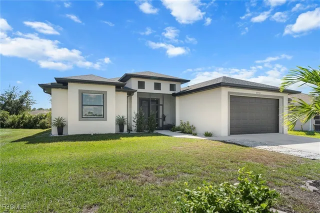 a front view of a house with a yard and garage