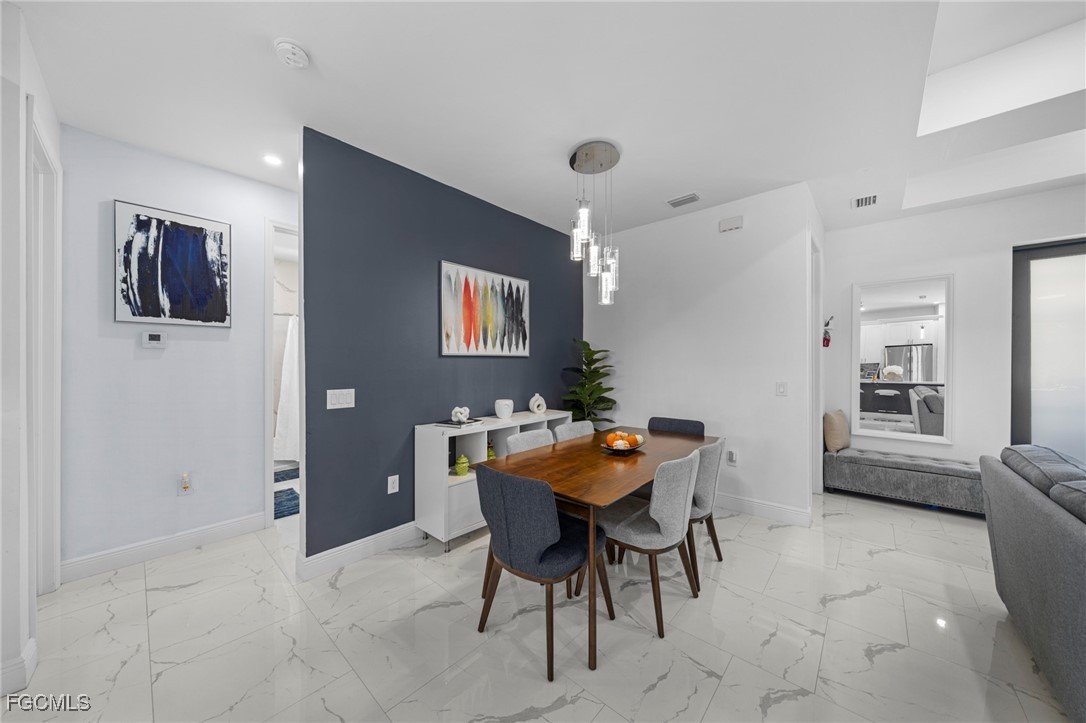 3713 25th Street Southwest Lehigh Acres, FL 33976 - Photo 12 of 31 a view of a dining room with furniture and chandelier