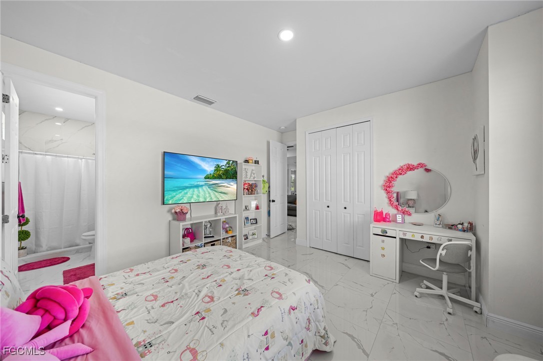 3713 25th Street Southwest Lehigh Acres, FL 33976 - Photo 17 of 31 a bedroom with a bed and a flat screen tv