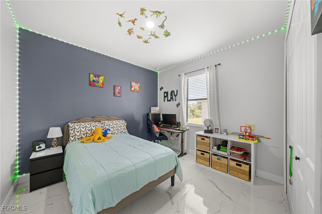 3713 25th Street Southwest Lehigh Acres, FL 33976 - Photo 19 of 31 a bedroom with a bed and furniture