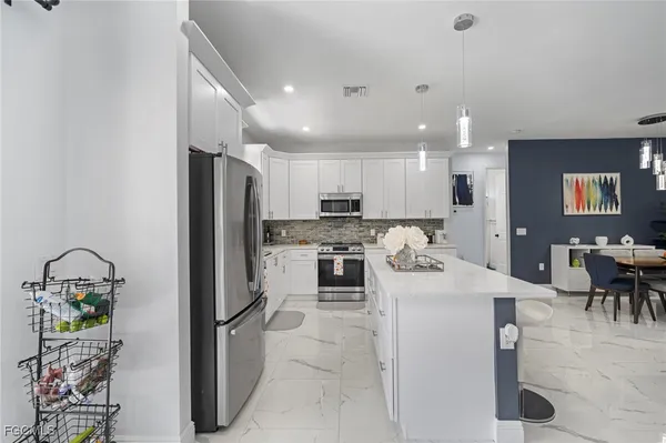 a kitchen with a refrigerator and a dining table