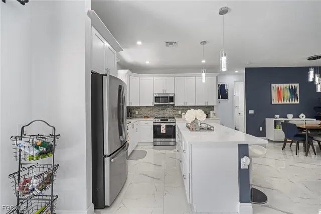 a kitchen with a refrigerator and a dining table