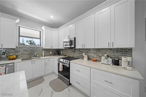 a kitchen with stainless steel appliances granite countertop a sink stove and cabinets