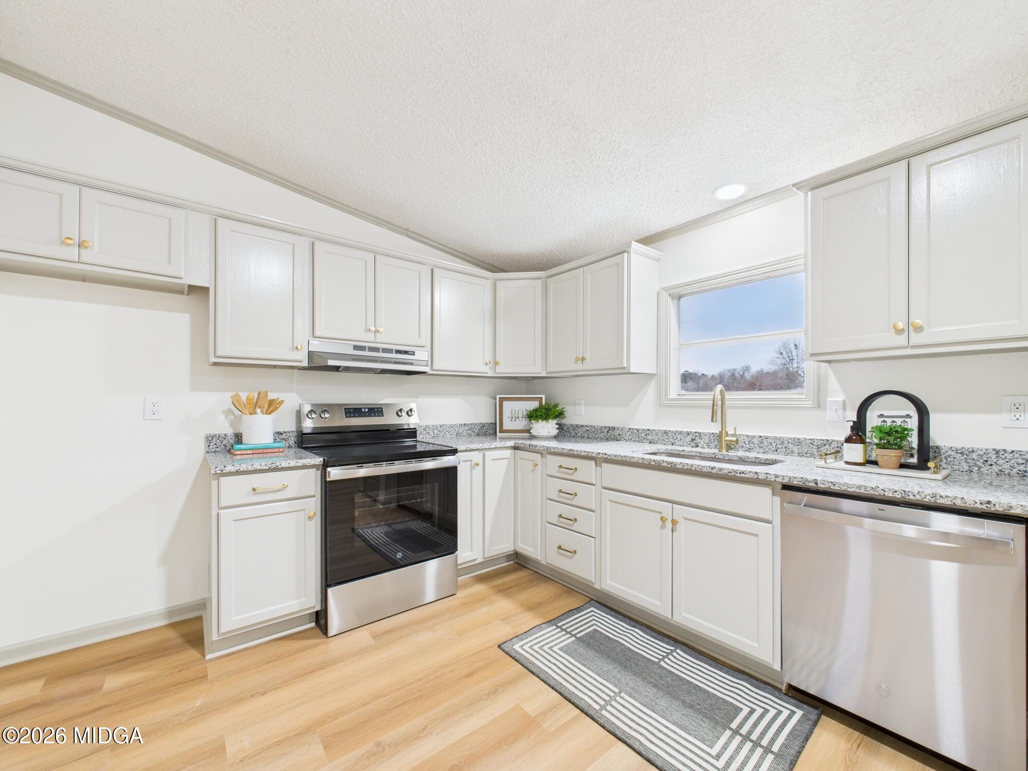 1850 Stallings Road Haddock, GA 31033 - Photo 14 of 44 a kitchen with stainless steel appliances granite countertop a stove sink and cabinets