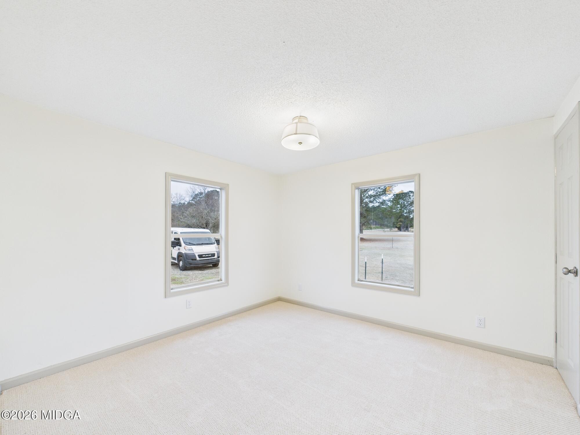 1850 Stallings Road Haddock, GA 31033 - Photo 20 of 44 an empty room with windows and cabinet