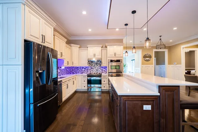 a living room with furniture a flat screen tv and kitchen view