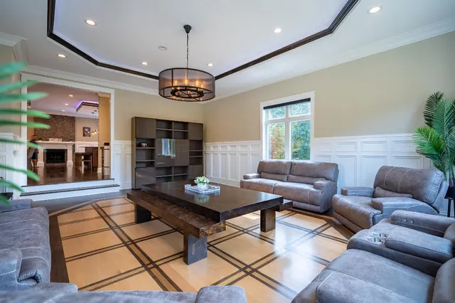 a living room with furniture chandelier and large windows