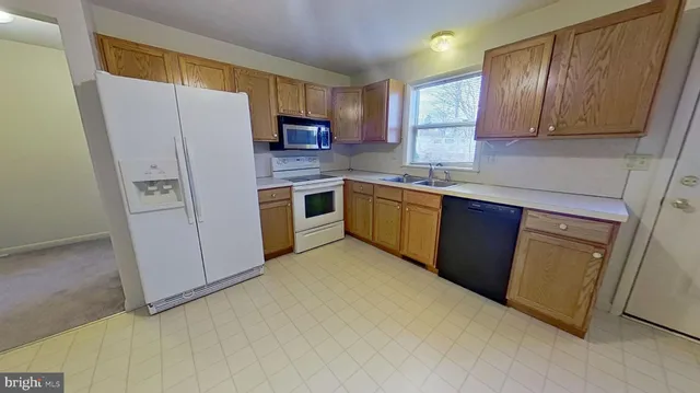 a kitchen with stainless steel appliances granite countertop a refrigerator a stove top oven a sink and dishwasher