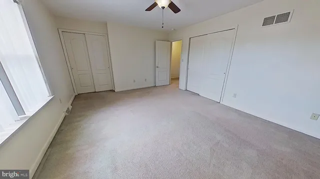 a view of an empty room and a chandelier fan